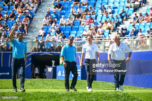 Footballers Gareth Bale and Andriy Shevchenko walk with Corey Pavin and Colin Montgomerie smile as they arrive on the first tee for the All Star...