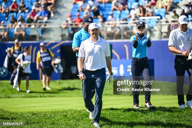 Former NFL player Victor Cruz, Garrett Hilbert of Dude Perfect and actress Kathryn Newton smile as they arrive on the first tee for the All Star...