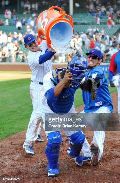 Anthony Rizzo of the Chicago Cubs and Matt Garza attack teammate Dioner Navarro with water and shaving cream as he is interviewed after the game...