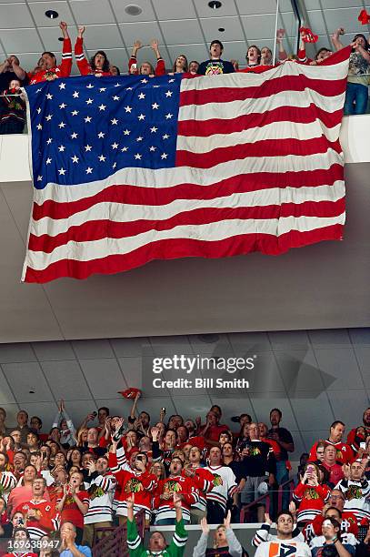 Fans hold the American flag in Game Seven of the Western Conference Semifinals between the Detroit Red Wings and the Chicago Blackhawks during the...