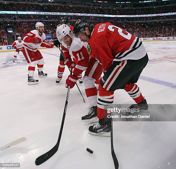Duncan Keith of the Chicago Blackhawks battles for the puck with Daniel Cleary of the Detroit Red Wings in Game Seven of the Western Conference...