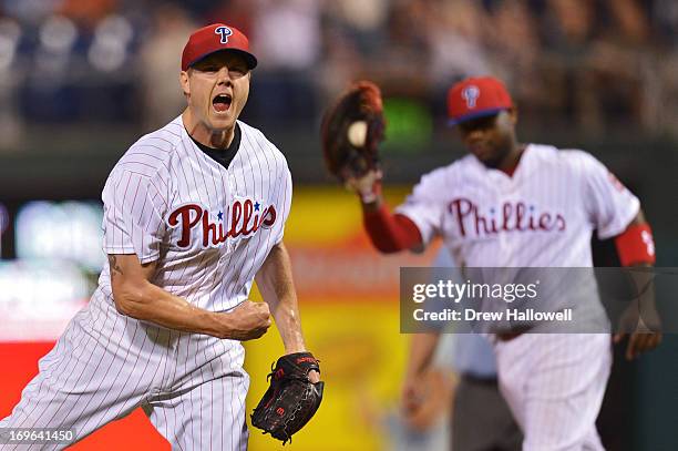 Jonathan Papelbon of the Philadelphia Phillies celebrates his 11th save of the season, as Ryan Howard shows the ball after beating the Boston Red Sox...