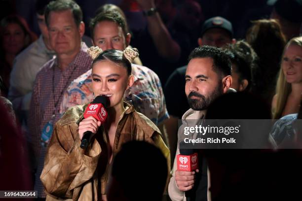 Agnez Mo and President and Chief Creative Officer of iHeart Latino Enrique Santos speak during the 2023 iHeartRadio Music Festival at T-Mobile Arena...