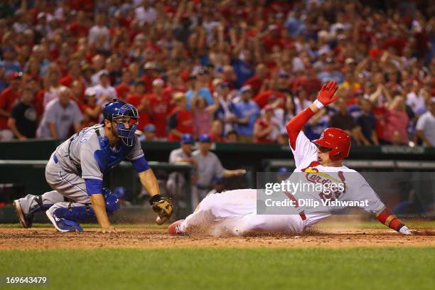 Allen Craig of the St. Louis Cardinals scores the game-tying run against George Kottaras of the Kansas City Royals in the eighth inning at Busch...