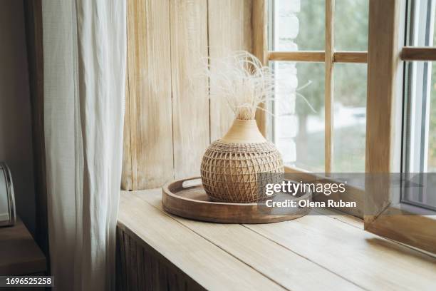 vase with feathery plant on a windowsill. - window sill stock pictures, royalty-free photos & images