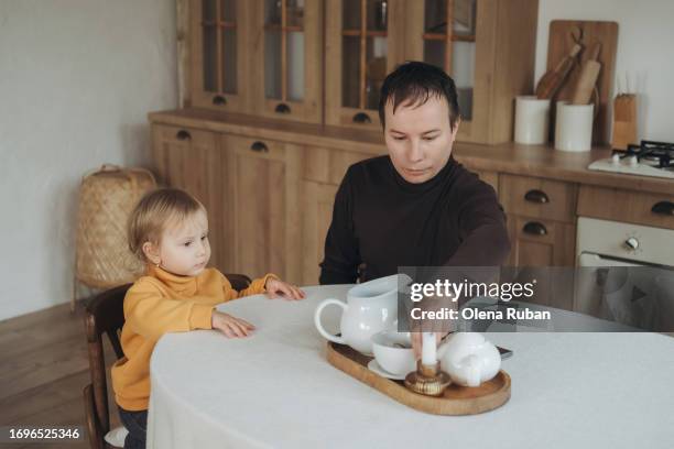 a girl and her father sitting at the table in a kitchen. - blonde wood texture stockfoto's en -beelden