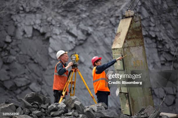 Mine surveyors work in the open pit of the Lebedinsky GOK iron ore mining and processing plant, operated by Metalloinvest Holding Co., in Gubkin,...