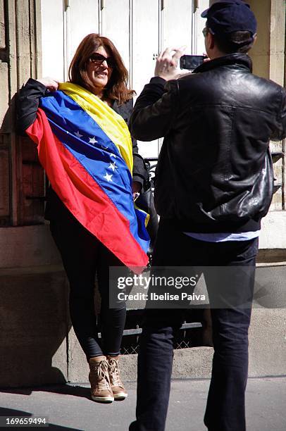 Woman holds Venezuela's flag while man takes her picture during the presidential elections of Venezuela. Venezuela's embassy in Paris. April 14th...