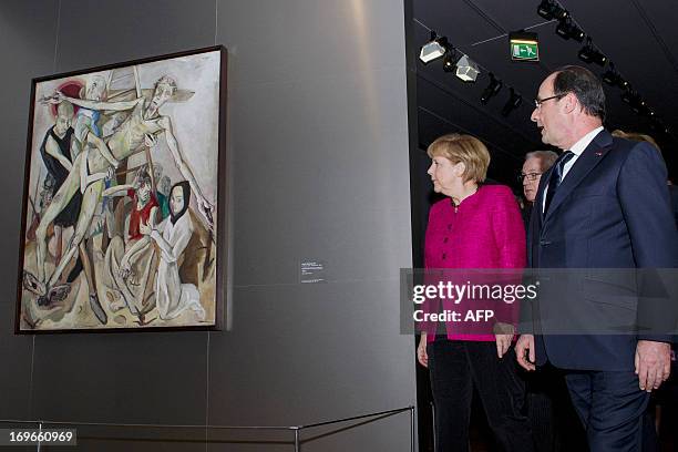 French President Francois Hollande and German Chancellor Angela Merkel look at a painting by German George Grosz entitled "Fit for active service" as...