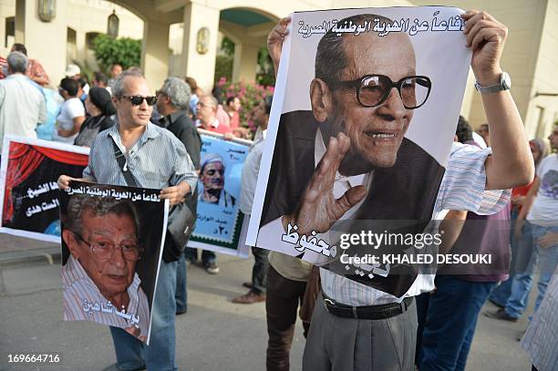 Egyptian employees of the Cairo Opera House and opponents of Egypt's Islamist president Mohamed Morsi hold a portrait of the late Nobel Prize for...