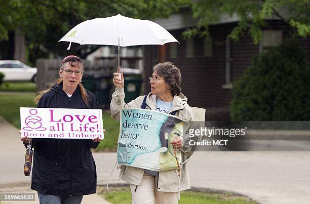 Susan Martinek, right, and Mary Cherion pray as they walk the block around the Cedar Rapids, Iowa, Planned Parenthood, on Wednesday, May 29, 2013....