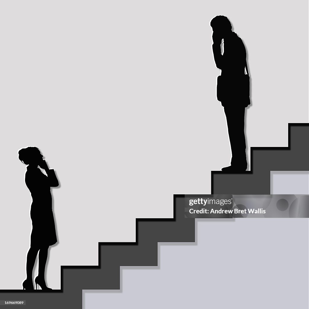 Male and female on stairs talk on their mobiles