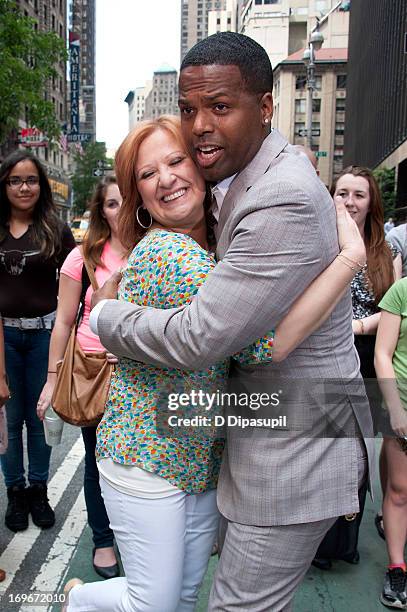 Calloway hugs Caroline Manzo of "Real Housewives of New Jersey" during her visit to "Extra" in Times Square on May 30, 2013 in New York City.