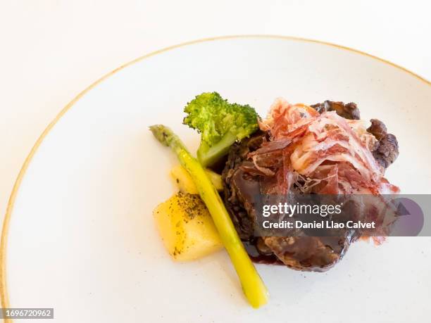 beef tenderloin with jamón ibérico and vegetables - jamón stockfoto's en -beelden