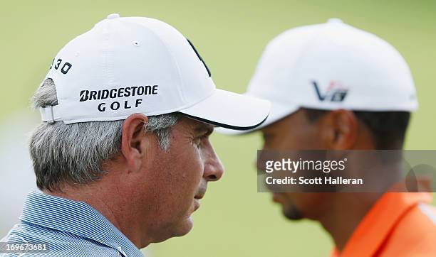 Fred Couples and Tiger Woods wait on the 13th green during the first round of the Memorial Tournament presented by Nationwide Insurance at Muirfield...