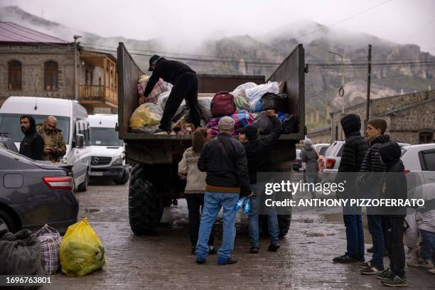 Goris, Armenia. Refugees of Nagorno Karabakh unload militarty trucks of their personal belongings. Some only have a small bag of some clothes and...