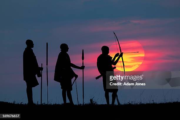 masai men silhouetted at sunrise - masai warrior stockfoto's en -beelden
