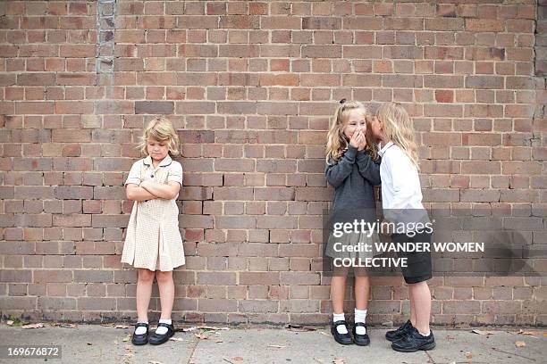 bullying and whispering school kids in uniform - いじめ ストックフォトと画像