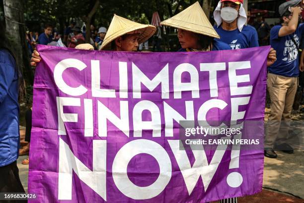 Protesters hold a sign reading "Climate Finance Now" during a demonstration at Liwasang Bonifacio in Manila on September 29 to demand the US...