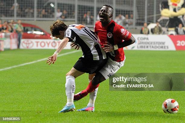 Tijuana's Duvier Riascos is fouled by Atletico's Richarlyson during their Libertadores Cup quarterfinals match at Arena Independencia Stadium in Belo...