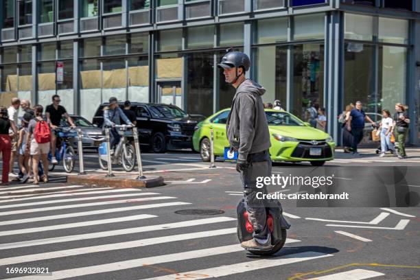 man on a electric monowheel in traffic - monowheel stockfoto's en -beelden