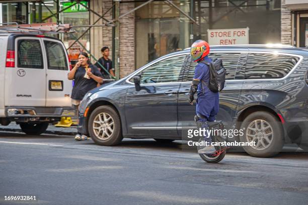 man on a electric monowheel in traffic - monowheel stockfoto's en -beelden