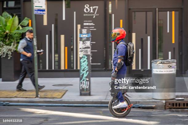 man on a electric monowheel in traffic - monowheel stockfoto's en -beelden