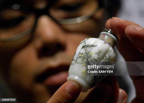 Yeh Chih-cheng, a Taiwanese snuff bottle collector, displays a Ching Dynasty snuff bottle during an exhibition in Taipei on August 28, 2008. The...
