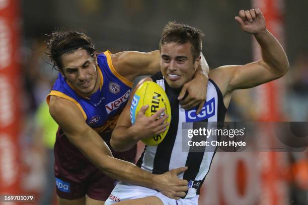 Ben Kennedy of the Magpies is tackled by Patrick Karnezis of the Lions during the round ten AFL match between the Brisbane Lions and the Collingwood...