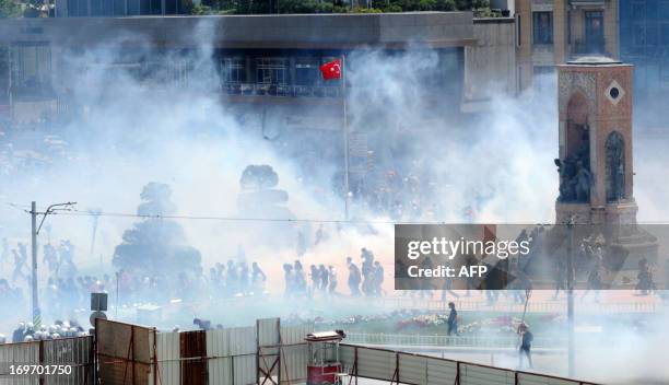 Demonstrators help one another as Turkish riot policemen use tear gas to disperse clashes on May 31, 2013 during a protest against the demolition of...