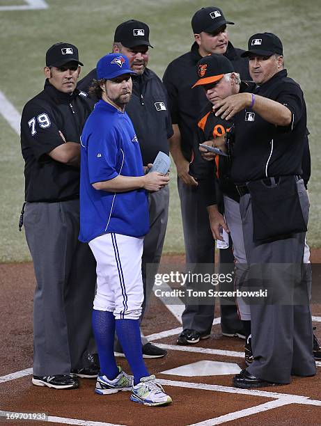 Dickey of the Toronto Blue Jays and manager Buck Showalter of the Baltimore Orioles deliver the lineups to home plate umpire Tony Randazzo and third...