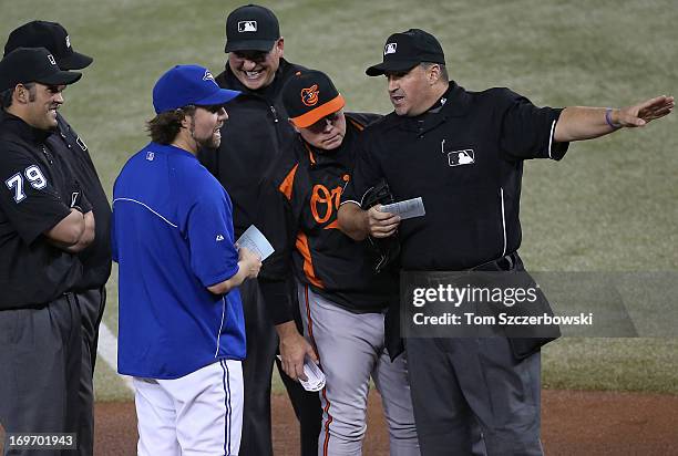 Dickey of the Toronto Blue Jays and manager Buck Showalter of the Baltimore Orioles deliver the lineups to home plate umpire Tony Randazzo and third...