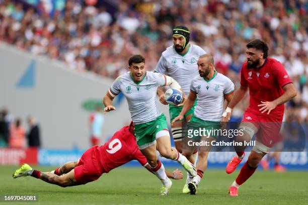 Raffaele Storti of Portugal breaks past Gela Aprasidze of Georgia before going on to score his team's first try during the Rugby World Cup France...