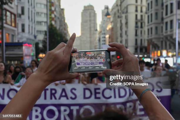 Protester records the protesters with her mobile phone during the demonstration in the center of Madrid. On the occasion of the commemoration of the...