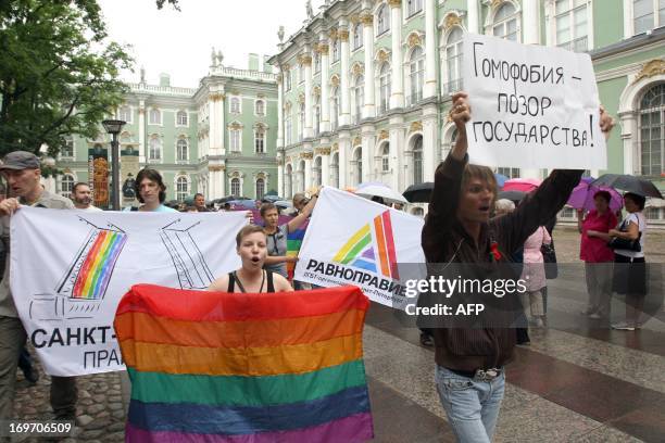 Russian gay rights activist holds a banner reading "Homophobia - disgrace of a country" during the gay pride protest, near the Hermitage Museum, in...