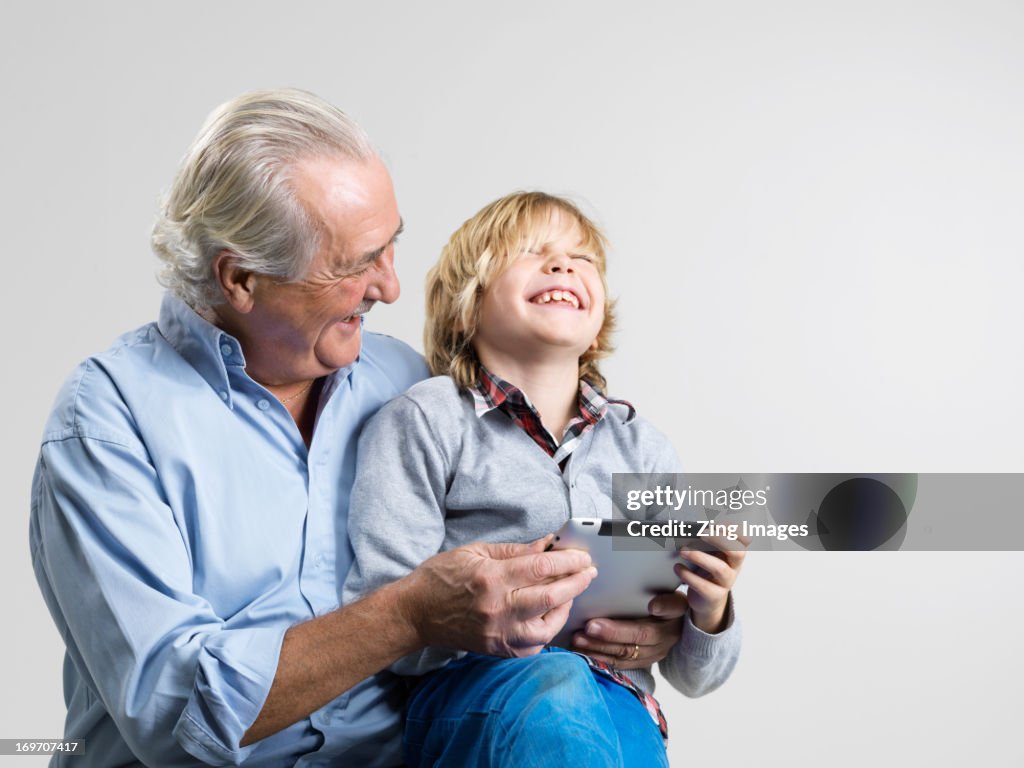 Grandfather and grandson using digital tablet