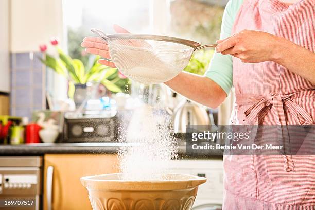 sieving flour in bowl, close up. - woman back stock-fotos und bilder