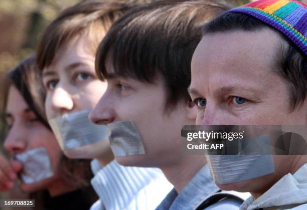 Members of a gay rights group sit with duct tape covering their mouths at a protest in St. Petersburg on May 3, 2008. The LGBT rights awareness group...