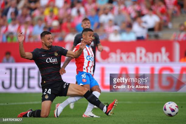 Martin Valjent of RCD Mallorca battles for possession with Savio of Girona during the LaLiga EA Sports match between Girona FC and RCD Mallorca at...