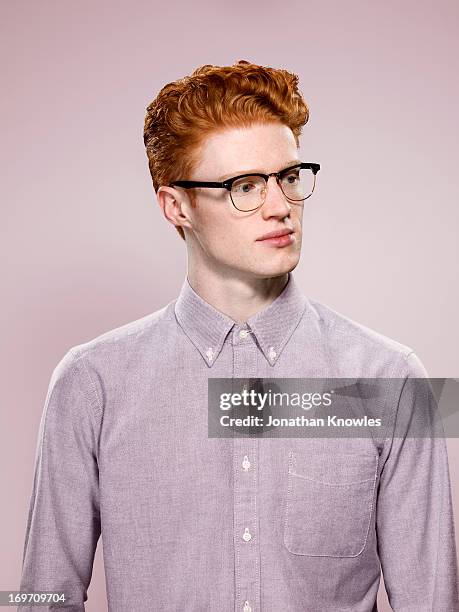 male with wavy red hair and glasses, looking away - red shirt stockfoto's en -beelden