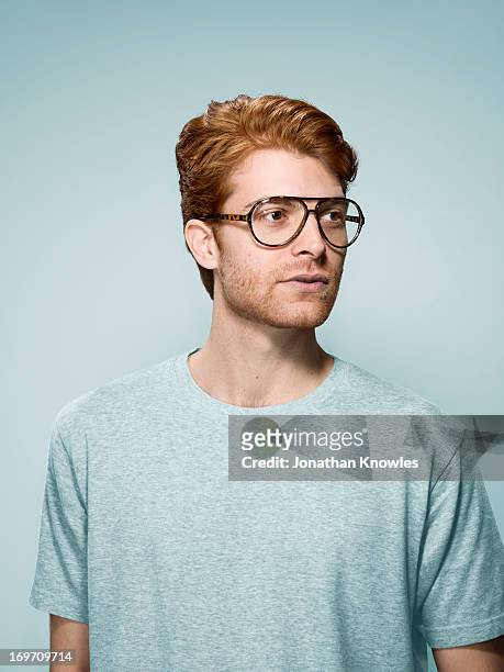 red hair male with glasses looking away - handsome man serious tshirt stock-fotos und bilder