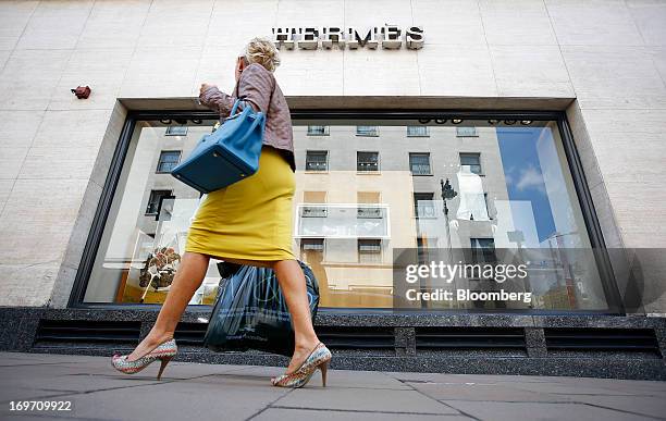 Pedestrian carries a Marks & Spencer Group Plc shopping bag as she walks past a Hermes store, operated by Hermes International SCA, on New Bond...