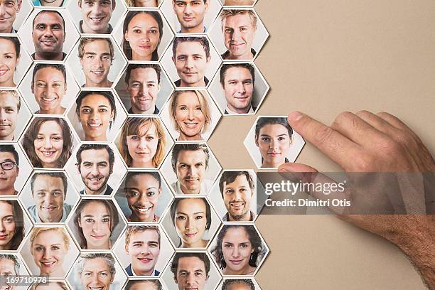 grid of hexagonal portraits, hand adding new one - hr stock-fotos und bilder