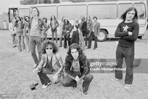 English glam rock group T-Rex and their entourage by their tour bus during a four-date British tour, June 1972. Foreground, left to right: bassist...