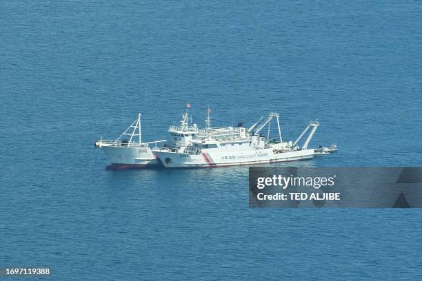 This photo taken on September 28, 2023 shows an aerial view of Chinese coast guard ships anchored inside the lagoon of the Chinese-controlled...