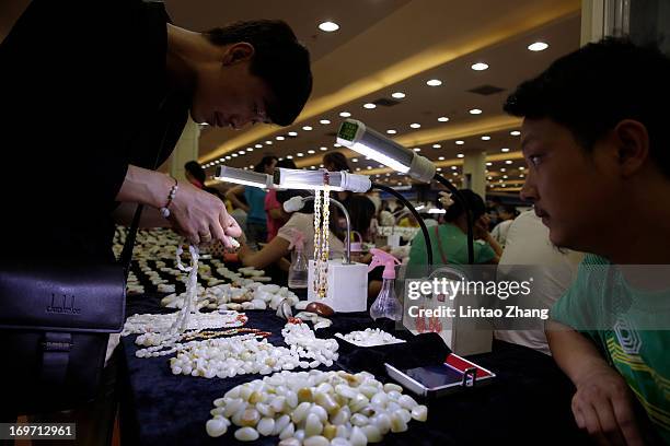 Customers select jade at the Shifosi early market on May 27, 2013 in Shifosi town of Henan province, China. Zhenping is one of the 14 counties in...