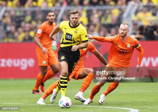 Niclas Fuellkrug of Borussia Dortmund controls the ball whilst under pressure from Maximilian Arnold of VfL Wolfsburg during the Bundesliga match...