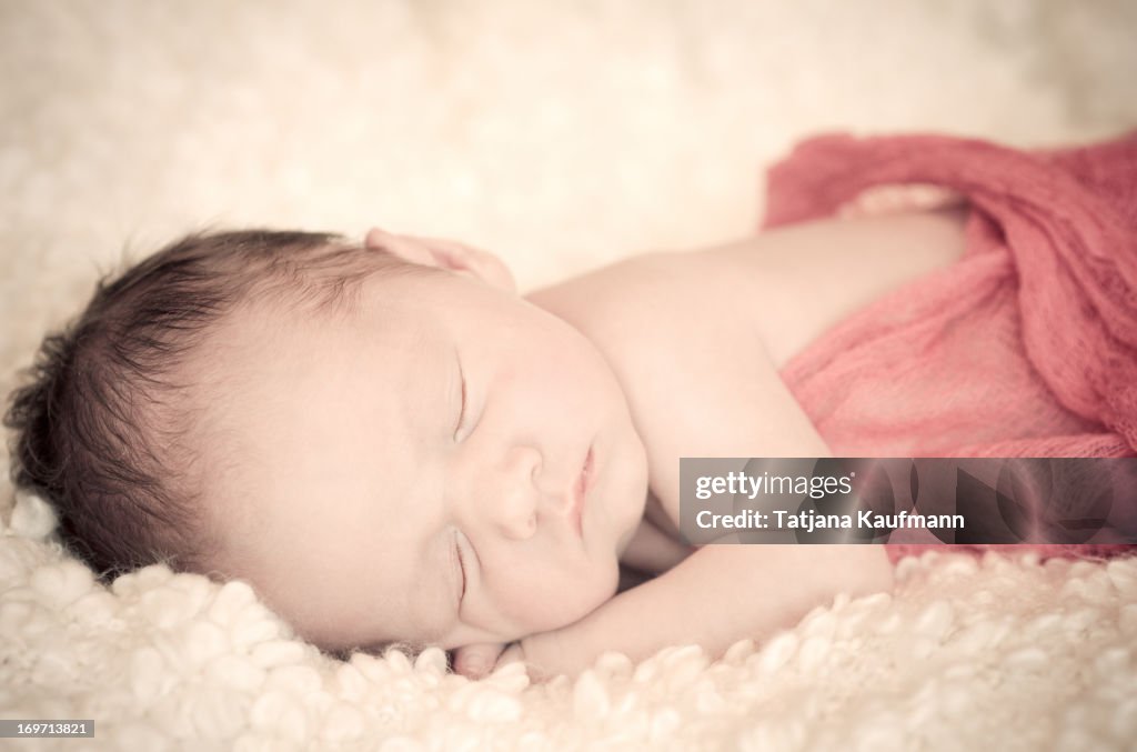 Newborn baby sleeping on a blanket