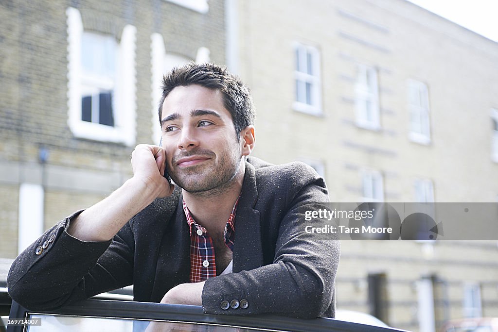 Man with mobile next to car