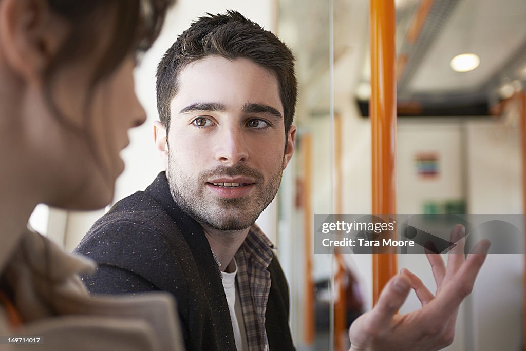 Man talking to woman in train
